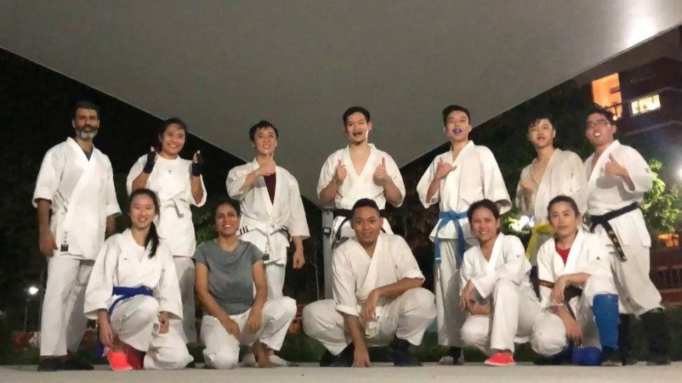 Karate practitioners posing after class in gi