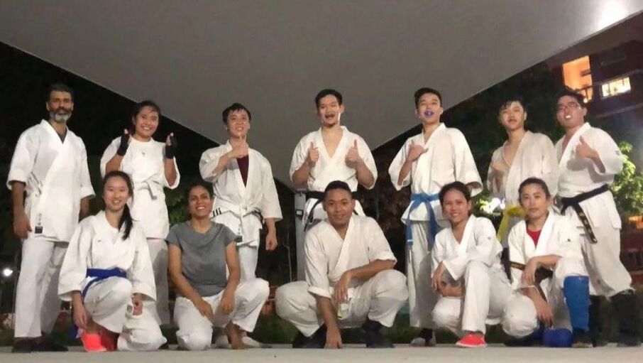 Karate practitioners posing after class in gi